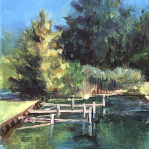 Bright summer image of Lakeside Yacht Club in Port Colborne, with bright green foreground and trees in the background.